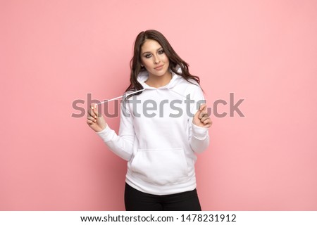 Attractive young woman in a white hoodie. Mock-up. Royalty-Free Stock Photo #1478231912