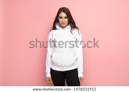 Attractive young woman in a white hoodie. Mock-up. Royalty-Free Stock Photo #1478231915