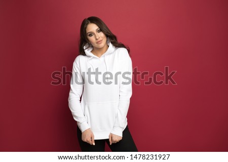 Attractive young woman in a white hoodie. Mock-up. Royalty-Free Stock Photo #1478231927