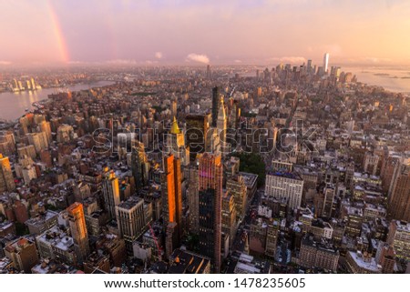 New York City skyline with Manhattan skyscrapers at dramatic vibrant after the storm sunset, USA. Rainbow can be seen in background over Brooklyn bridge.