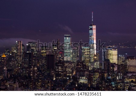 New York City skyline with lower Manhattan skyscrapers in storm at night.