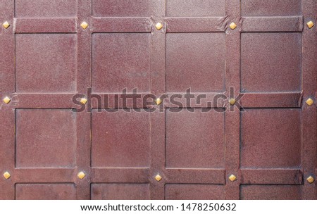 Brown forged iron door with rivets for texture or background, ancient architecture of castle gate backdrop.
