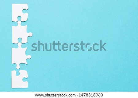 Row of white jigsaw puzzle on blue backdrop