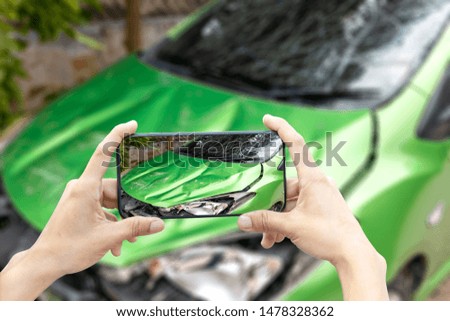 2 hand of woman hold smartphone for take photo of front green color car accident 