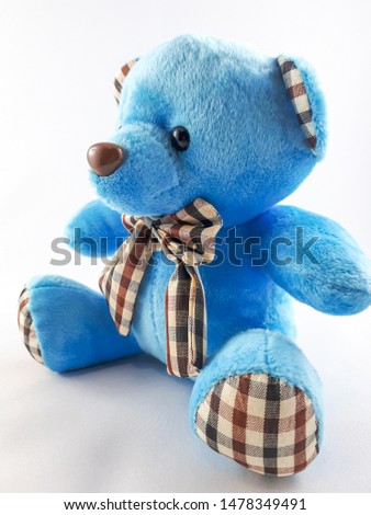 Cute blue teddy bear with a tie around his neck