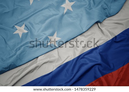 waving colorful flag of russia and national flag of Federated States of Micronesia. macro