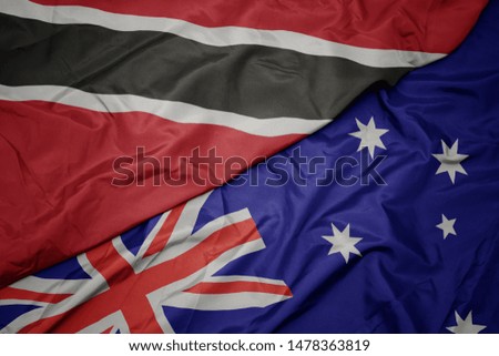 waving colorful flag of australia and national flag of trinidad and tobago. macro