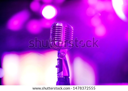 Karaoke background.Silver vintage microphone on bokeh.Close-up of retro microphone at concert.Professional microphone