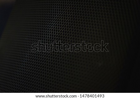 Protective decorative metal grill with honeycombs on modern acoustic systems. Music speakers close-up. Abstract background closeup, soft focus and beautiful bokeh.