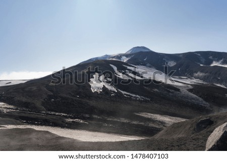 Magical morning in base camp. Kamchatka Peninsula, Russian far east. Mountain peaks and ribs of the active Avacha volcano. Snowy slopes in beautiful summer day.
