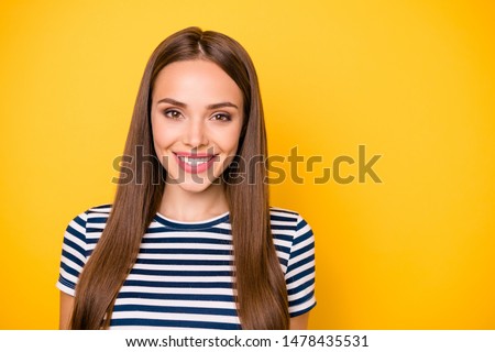 Close up photo of charming lady looking at camera smiling wearing striped t-shirt isolated over yellow background
