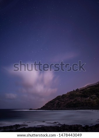 Landscape in Tenerife with a silky sea an moving clouds and stars