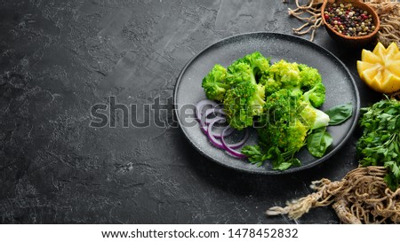 Boiled broccoli with spices on a stone plate. Top view. Free copy space.