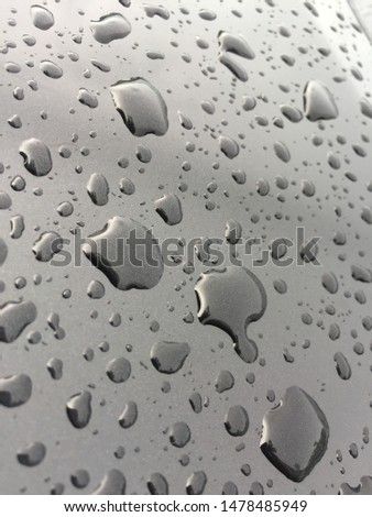 Clear water drops after rain, leather on a black car background