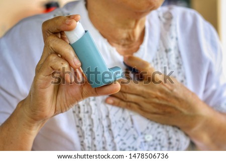 Elderly Female's hand holding inhaler with blurred background.Medication for relief bronchospasm or Dyspnea from asthma attack or allergy,that's an emergency condition.Healthcare and medical concept. Royalty-Free Stock Photo #1478506736