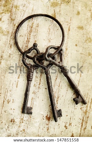 bunch of old keys on a wooden table 