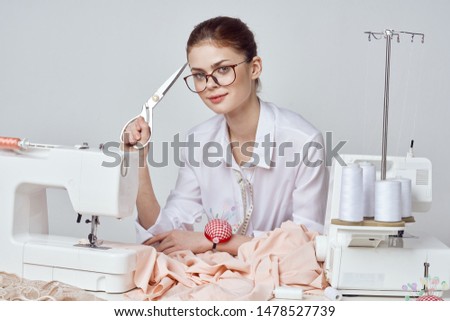     woman sews clothes on a sewing machine                           