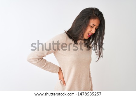 Beautiful chinese woman wearing turtleneck sweater standing over isolated white background Suffering of backache, touching back with hand, muscular pain Royalty-Free Stock Photo #1478535257