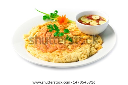 Omelet fried eggs Thai food style inside dish decorate with carved vegetables, carrots, spring onion with fish sauce spicy dipping side view