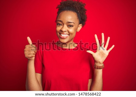 Young beautiful african american woman with afro hair over isolated red background showing and pointing up with fingers number six while smiling confident and happy.