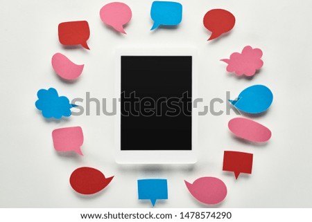 top view of digital tablet with blank screen in circle of empty speech bubbles, cyberbullying concept