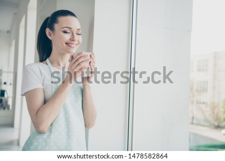 Photo of completely pleased and satisfied girl tasting newly bought tea after hard work day