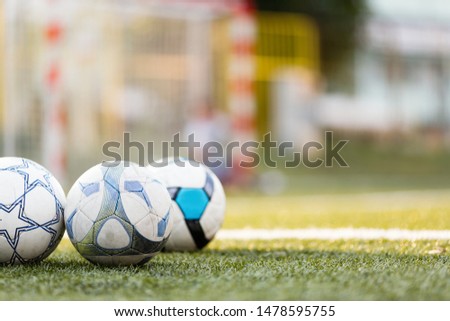 Picture of three soccer balls on field