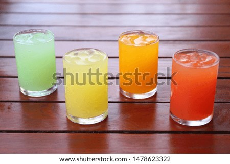 Refreshing drink of cold Juice  (pineapple, orange, punch, guava) on wood table.