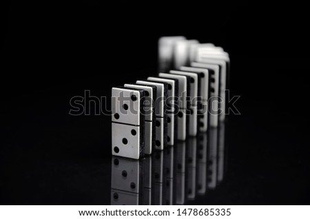 row of dominoes uprigh on black