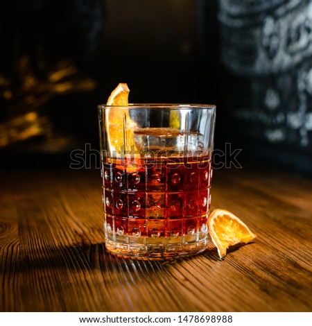 Cocktail Negroni on a old wooden board. Drink with gin, campari martini rosso and orange. negroni cocktail at the bar Royalty-Free Stock Photo #1478698988