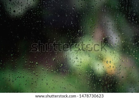 Rain drops of car windscreen with green background