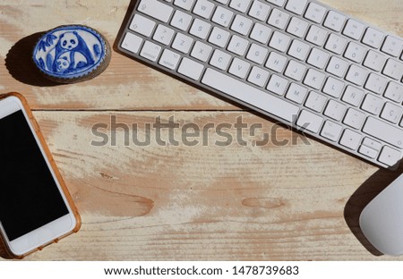 Modern desktop, Wireless computer keyboard and mouse with mobile phone on  recycled wooden desk. Flat lay photography with room for text
