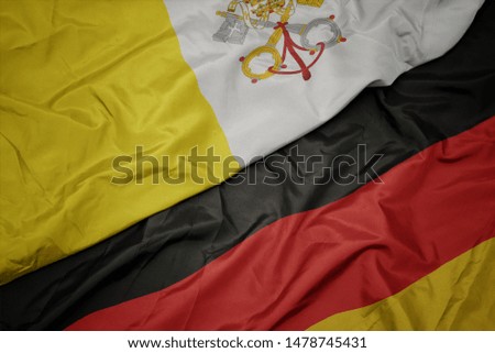 waving colorful flag of germany and national flag of vatican city. macro