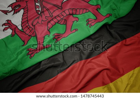 waving colorful flag of germany and national flag of wales. macro