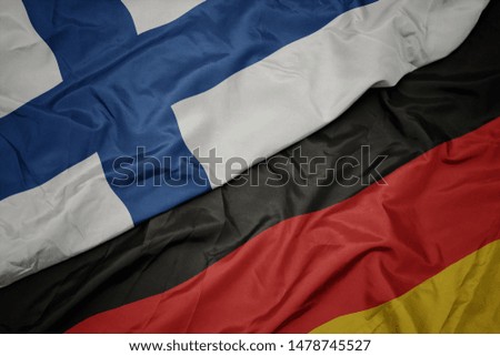 waving colorful flag of germany and national flag of finland. macro