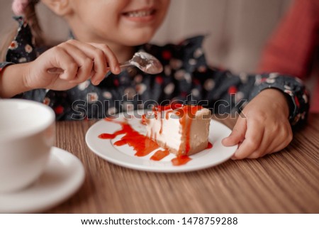 Little girl eating cake in cafe