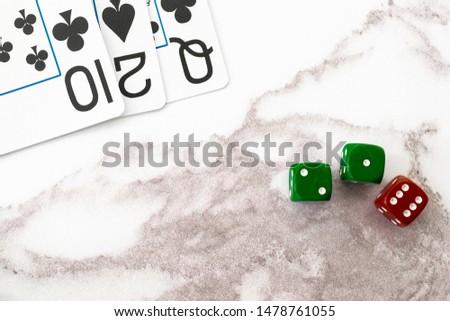Playing cards and dice on a marble background.