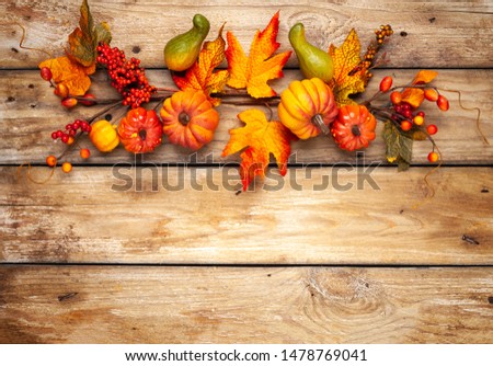 Festive autumn decor from pumpkins, berries and leaves on a rustic wooden background. Concept of Thanksgiving day or Halloween. Flat lay autumn composition with copy space.