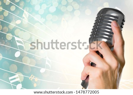 Retro style microphone in human hand on  background