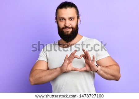happy handsome cheerful man making heart with fingers.close up portrait. isolated blue background. studio shot. I love you. body language