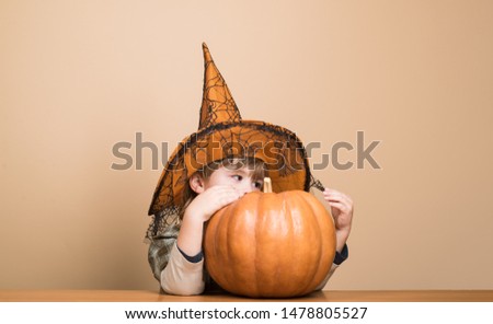 31 October. Preparation Halloween holidays. Child with pumpkin. Cute boy in witch hat with halloween pumpkin jack o lantern. Trick or treating. Magic pumpkin. Autumn. Halloween party. Happy Halloween.
