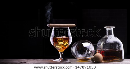 Cognac and Cigar on black background with wooden vintage table