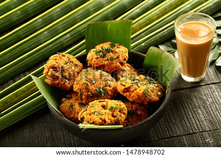 Delicious vegan snack foods- spicy fried parippu vada served with hot milk Indian tea, chai.