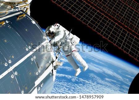 The astronaut in an outer space, at the ISS, repairs and makes experiments. Elements of this image were furnished by NASA Royalty-Free Stock Photo #1478957909