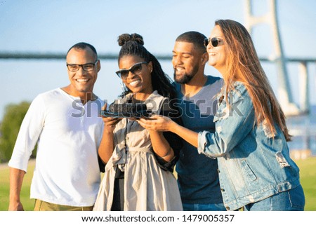 Laughing young people posing with brown cake. Beautiful African American woman with dreadlocks holding delicious birthday cake. Birthday holiday celebration concept