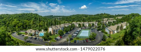 Aerial view of typical American midwest middle class apartment complex with club house, pool, tennis court and parking lot 