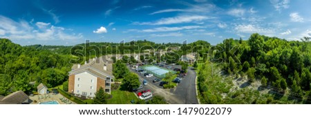 Aerial view of typical American midwest middle class apartment complex with club house, pool, tennis court and parking lot 