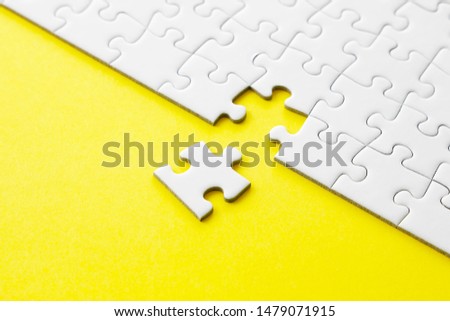 White jigsaw puzzle on yellow background