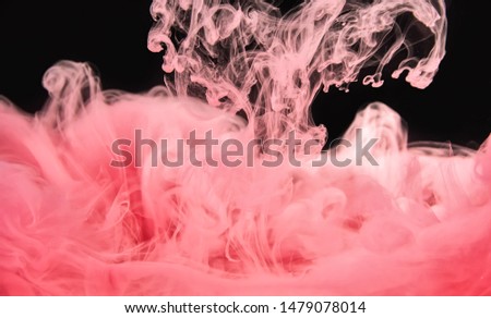 Acrylic paint cloud dissolving into water, isolated on black background, close up view. Movement of pink paint under water. Abstract background. Ready to use blending mode to screen or add
