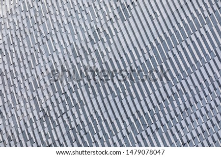 Skyscraper wall abstract background with repeated rectangular cells. Metal gray color with repetitive texture.